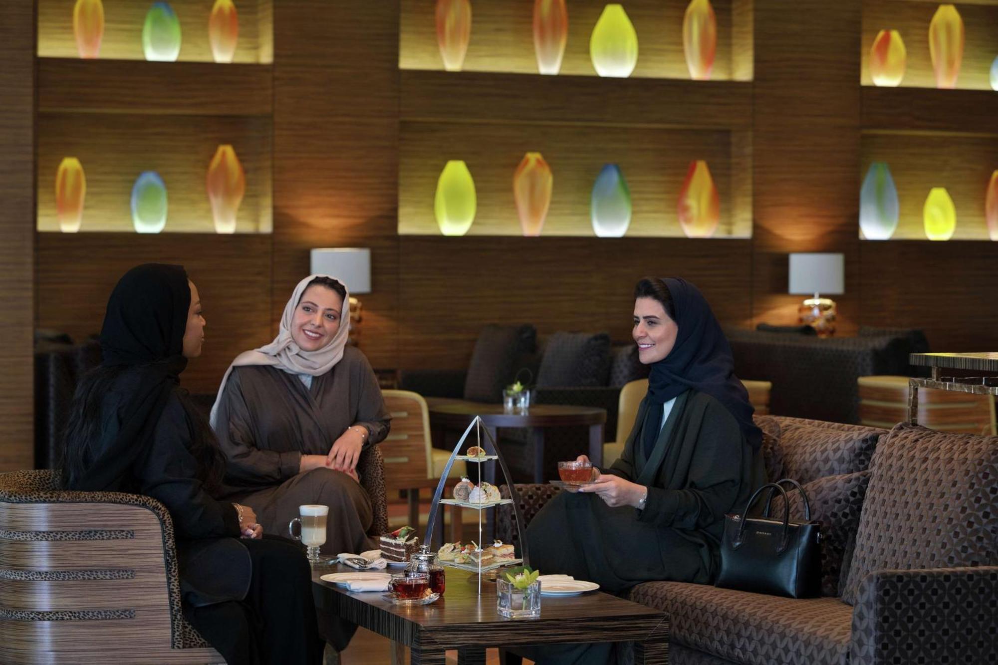 Hilton Riyadh Hotel & Residences Eksteriør bilde The photo shows three women sitting together in a cozy, well-decorated lounge. They appear to be enjoying each other's company, engaged in conversation and possibly sharing tea or refreshments. The setting features soft, modern lighting with decorati