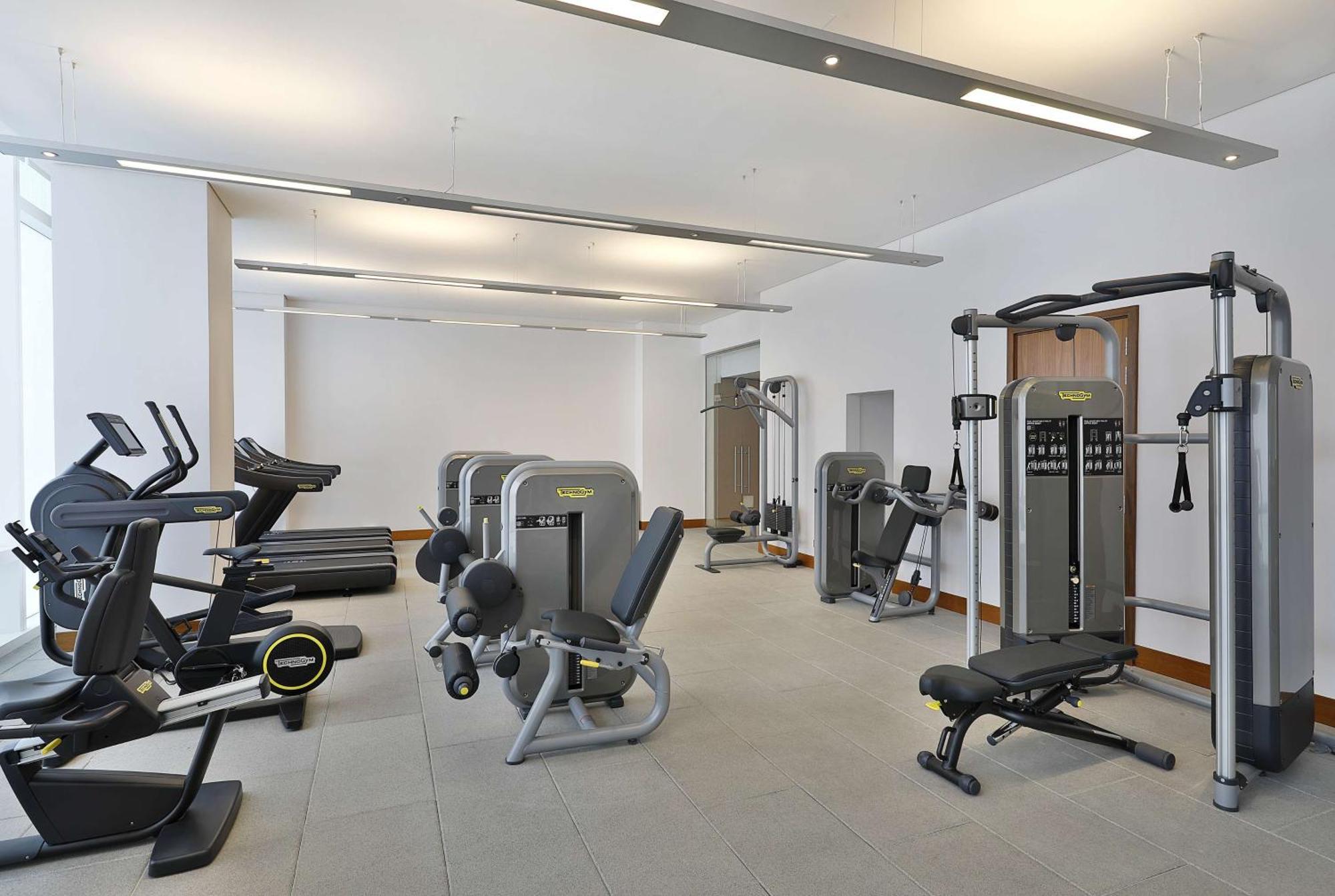 Hilton Riyadh Hotel & Residences Eksteriør bilde The photo shows a modern gym or fitness center with various exercise equipment. On the left, there are several treadmills, while the center features a range of weight machines. There is a multi-station gym equipment, and a bench press is also visible